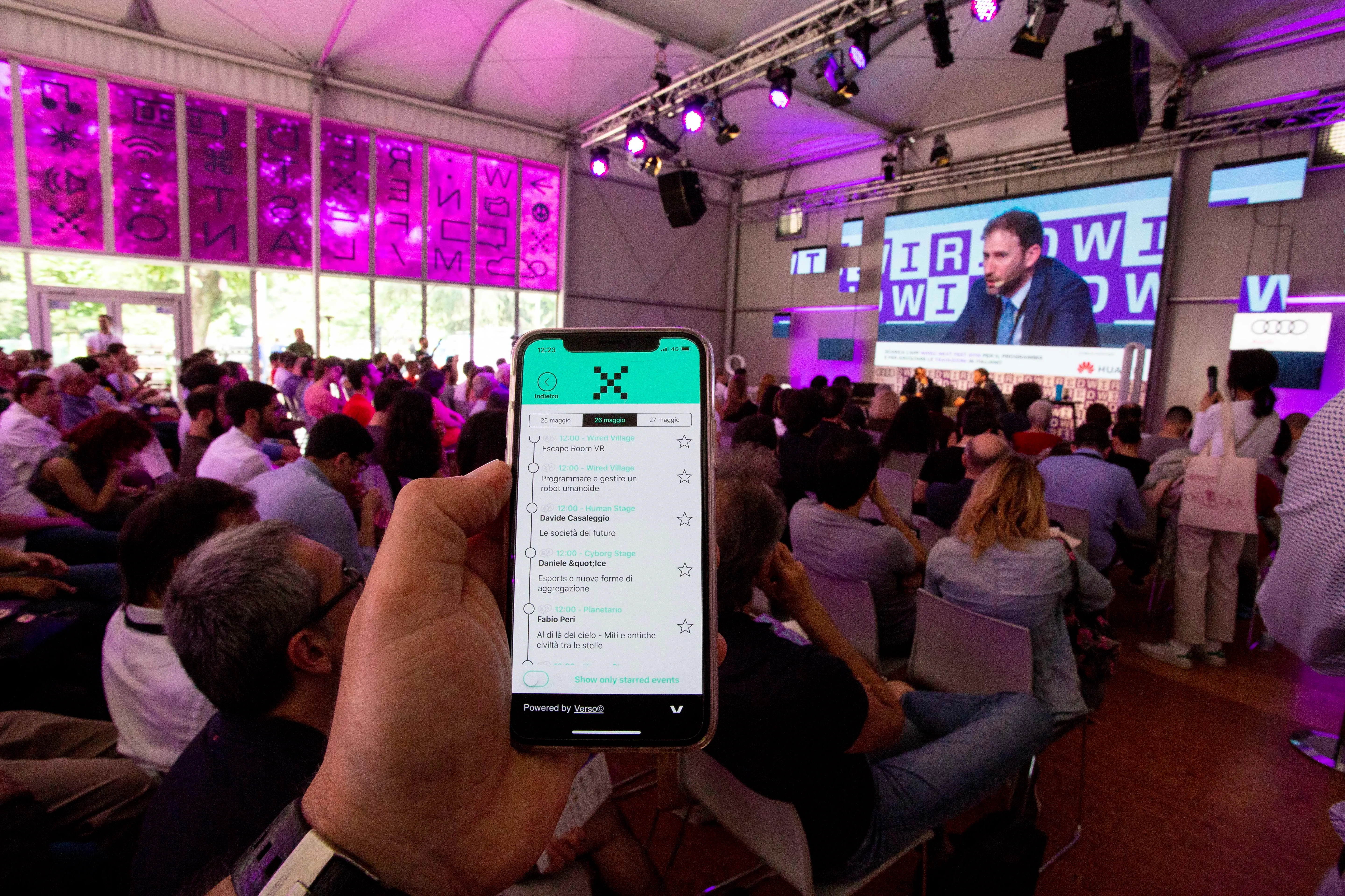 Application dans la main d'un participant montrant le programme live intégré