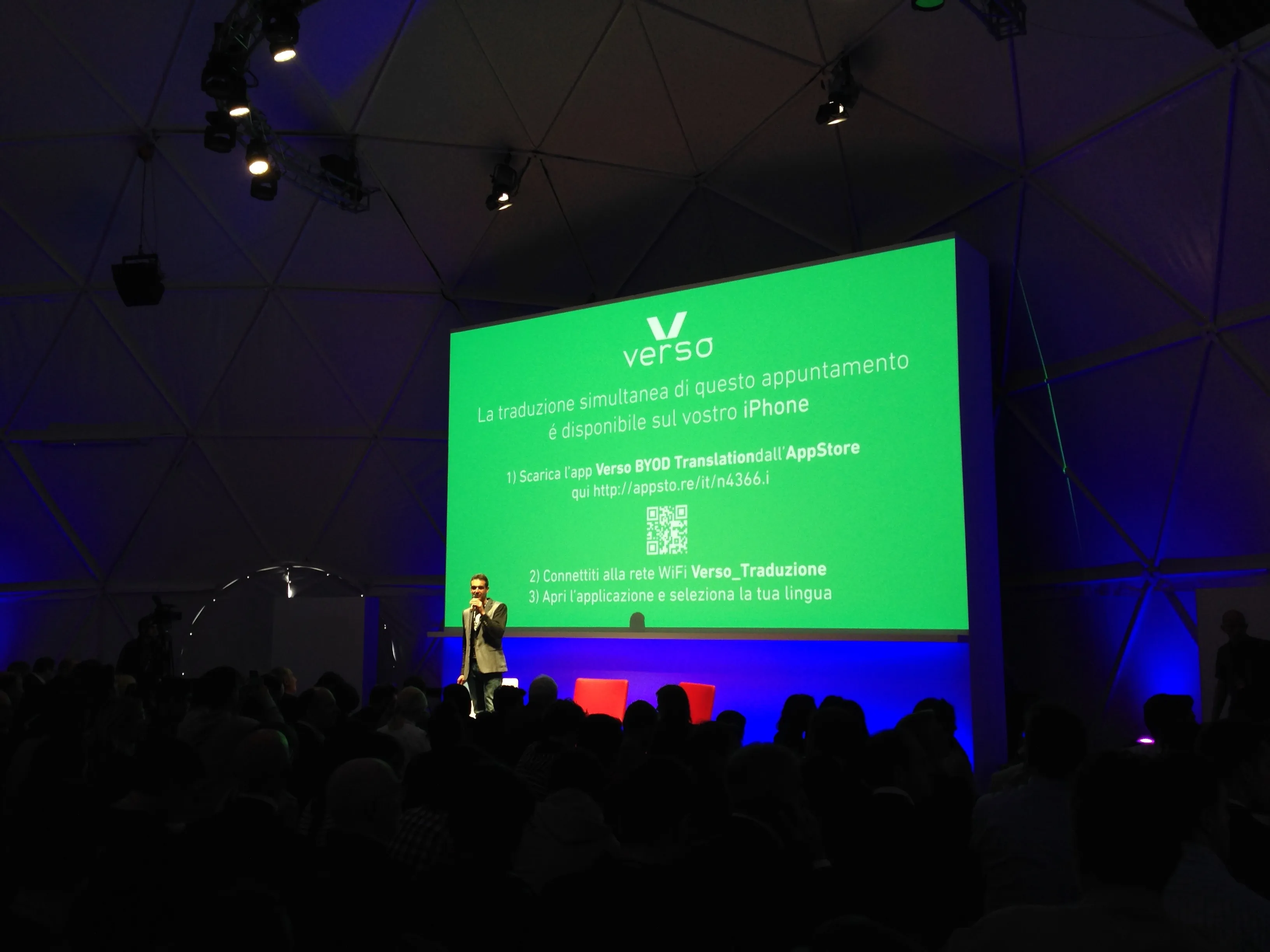 Scène du Wired Next Fest avec une slide BYOD Translation invitant au téléchargement de l'app Verso