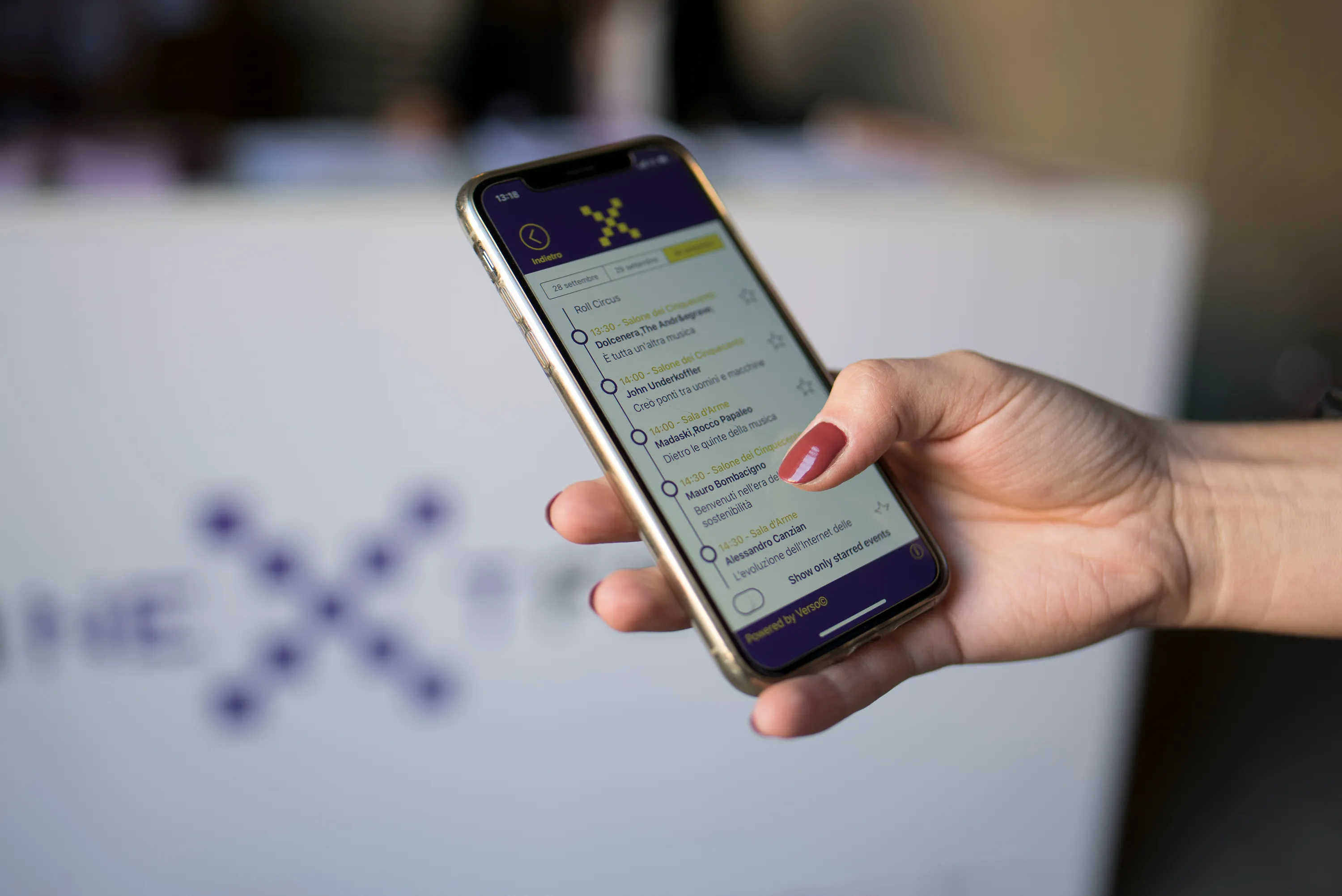Application dans la main d'un participant montrant le programme live intégré