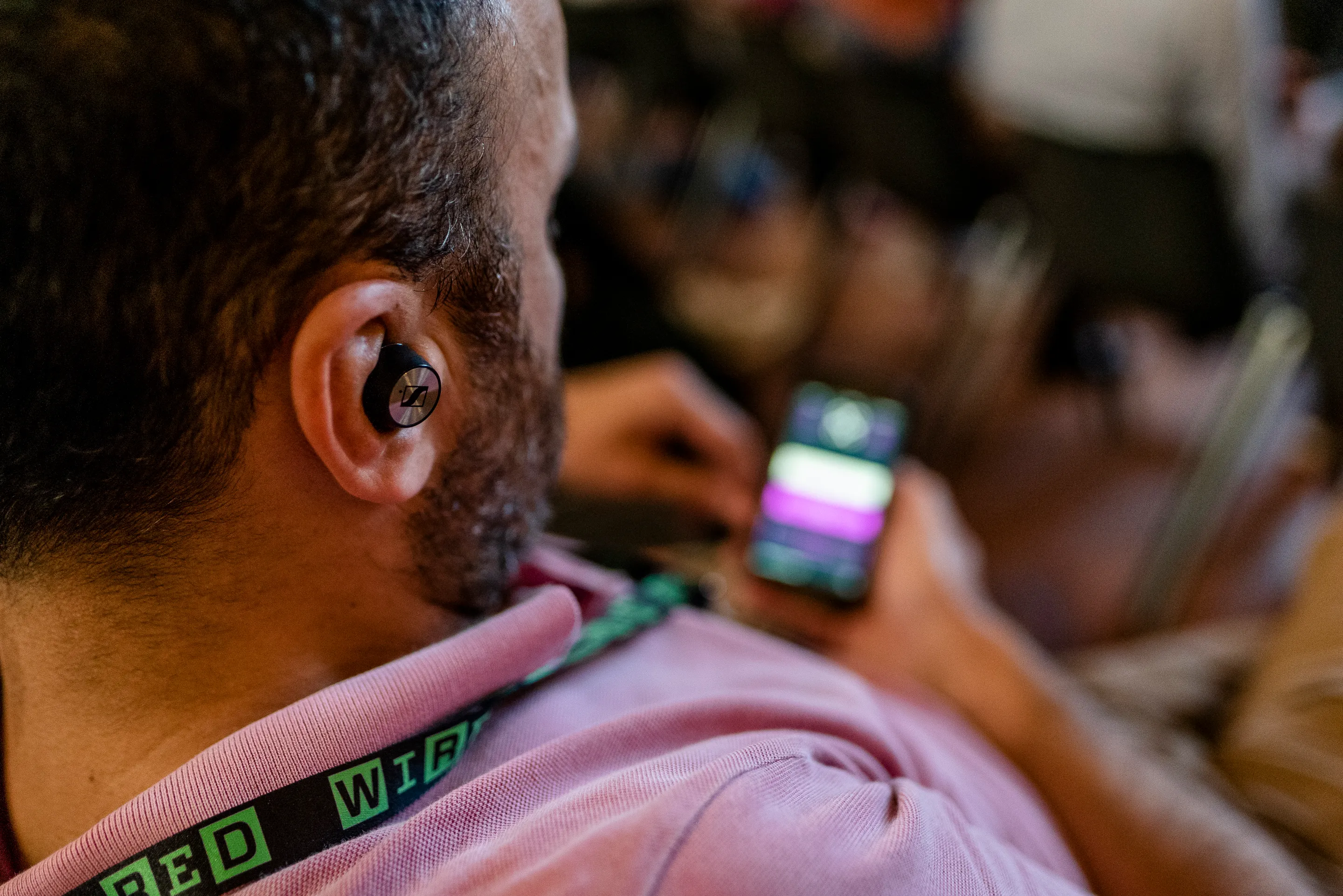 Participant avec écouteurs bluetooth qui suit la traduction simultanée via l'app